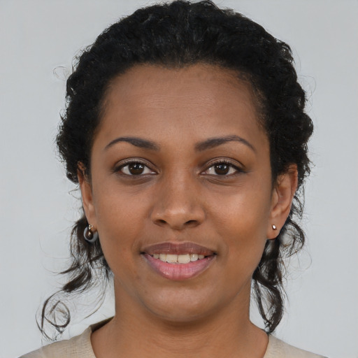 Joyful black young-adult female with medium  brown hair and brown eyes