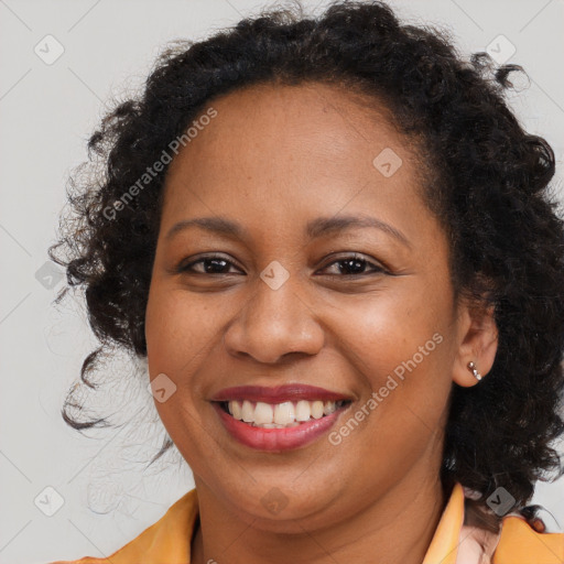 Joyful black adult female with long  brown hair and brown eyes