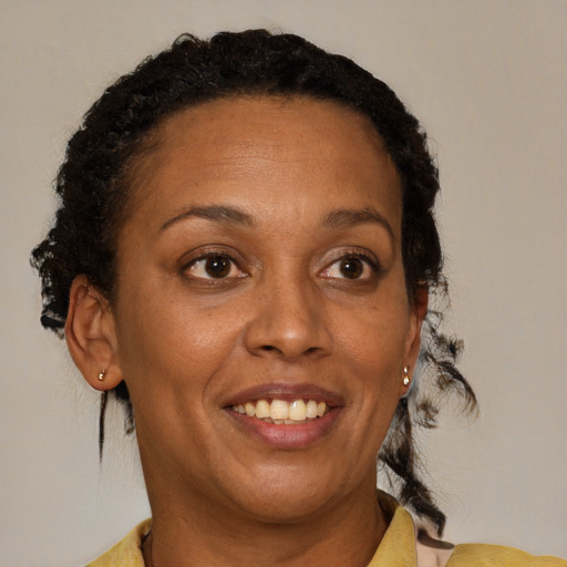 Joyful black adult female with medium  brown hair and brown eyes