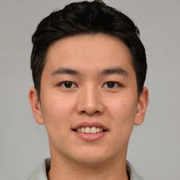 Joyful asian young-adult male with short  brown hair and brown eyes