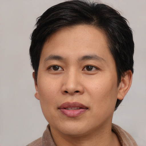 Joyful asian adult male with short  brown hair and brown eyes