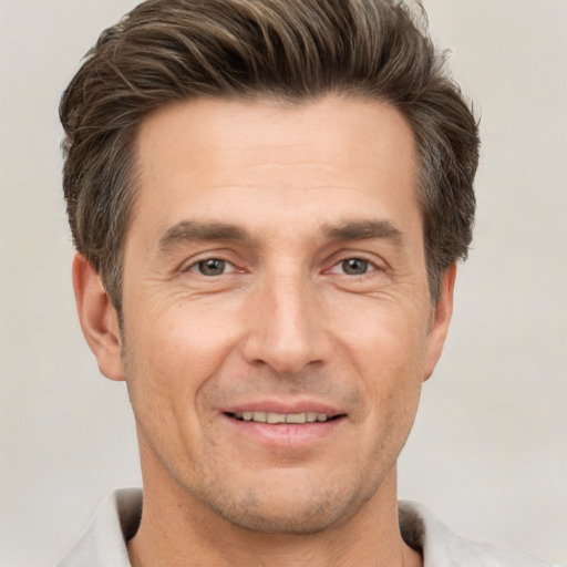 Joyful white adult male with short  brown hair and brown eyes