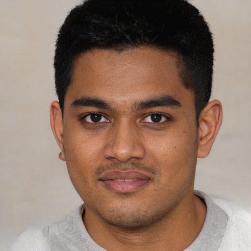 Joyful black young-adult male with short  black hair and brown eyes