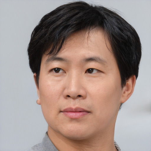 Neutral asian adult male with short  brown hair and brown eyes