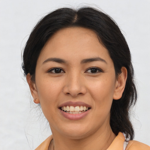 Joyful latino young-adult female with long  brown hair and brown eyes