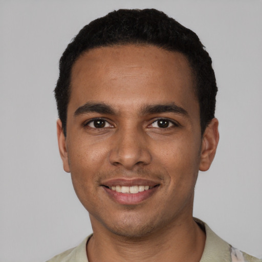 Joyful black young-adult male with short  black hair and brown eyes