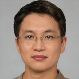 Joyful asian adult male with short  brown hair and brown eyes