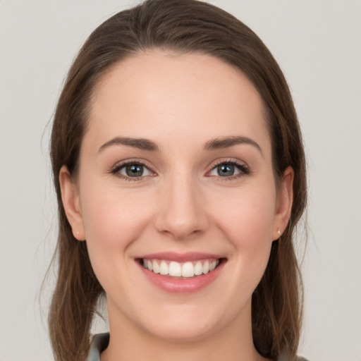 Joyful white young-adult female with long  brown hair and grey eyes