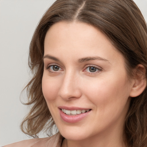 Joyful white young-adult female with long  brown hair and brown eyes