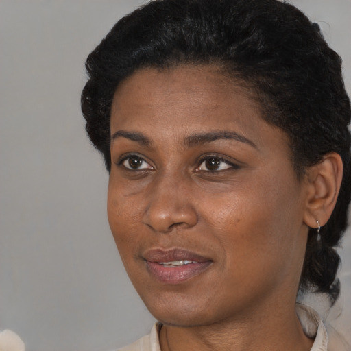 Joyful black young-adult female with short  black hair and brown eyes