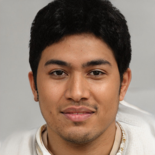 Joyful latino young-adult male with short  black hair and brown eyes
