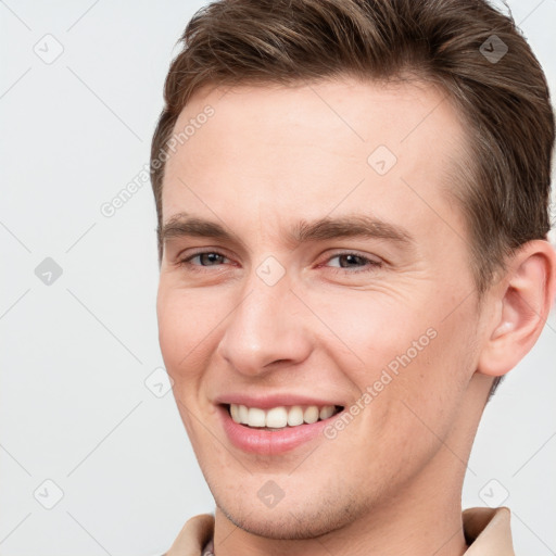 Joyful white young-adult male with short  brown hair and grey eyes