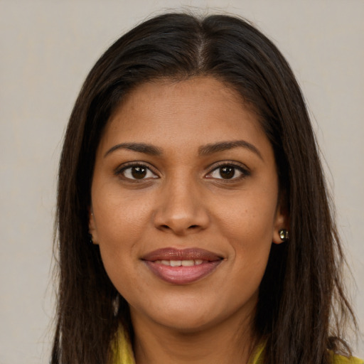 Joyful black young-adult female with long  brown hair and brown eyes