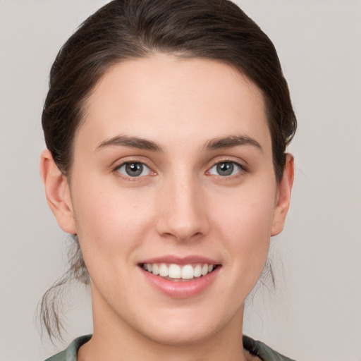 Joyful white young-adult female with short  brown hair and grey eyes