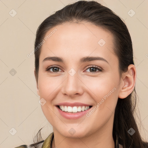 Joyful white young-adult female with long  brown hair and brown eyes