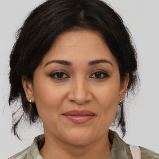 Joyful latino adult female with medium  brown hair and brown eyes