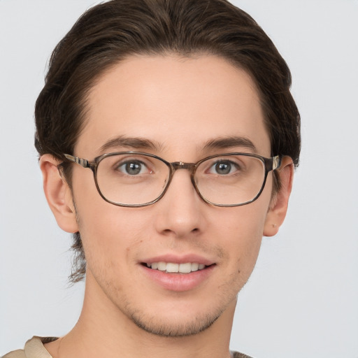 Joyful white young-adult male with short  brown hair and grey eyes