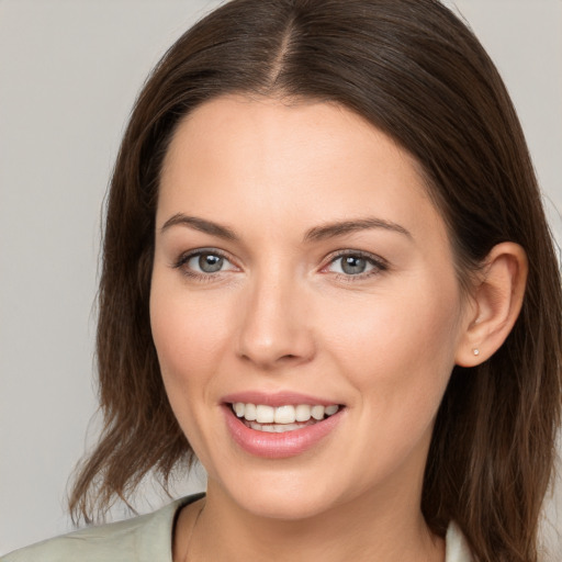 Joyful white young-adult female with long  brown hair and grey eyes