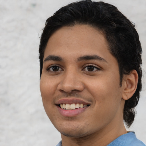 Joyful latino young-adult male with short  black hair and brown eyes