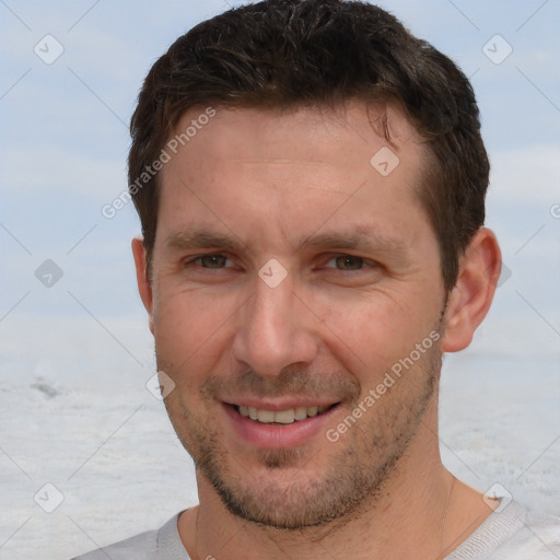 Joyful white adult male with short  brown hair and brown eyes