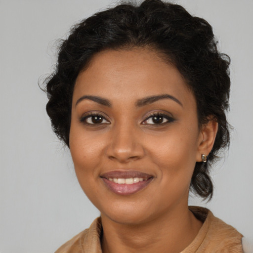 Joyful black young-adult female with long  brown hair and brown eyes