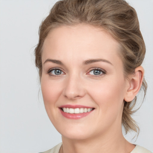 Joyful white young-adult female with medium  brown hair and grey eyes