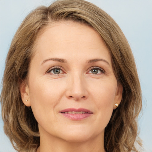 Joyful white adult female with medium  brown hair and green eyes