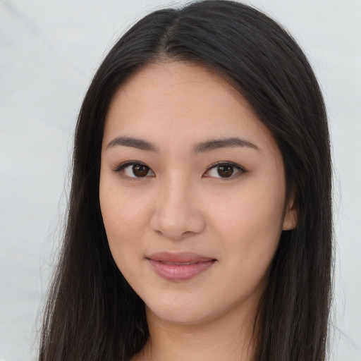 Joyful asian young-adult female with long  brown hair and brown eyes