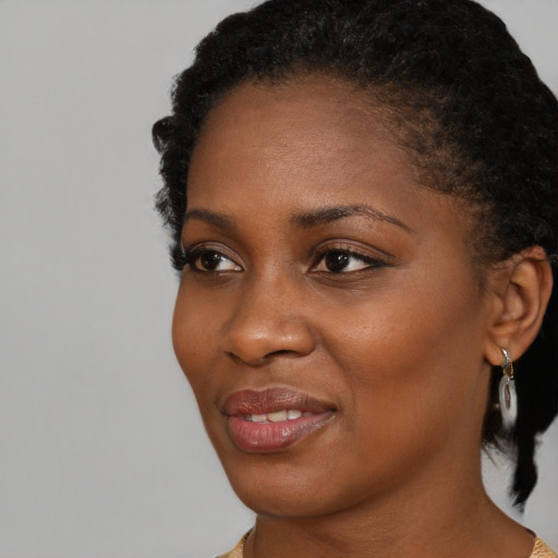 Joyful black young-adult female with short  black hair and brown eyes