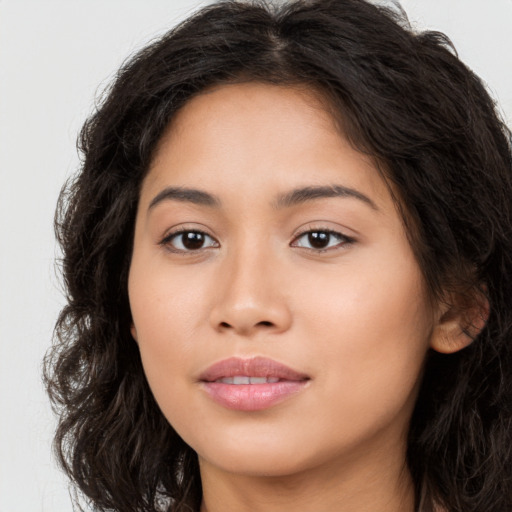 Joyful latino young-adult female with long  brown hair and brown eyes