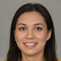 Joyful black young-adult female with long  brown hair and brown eyes