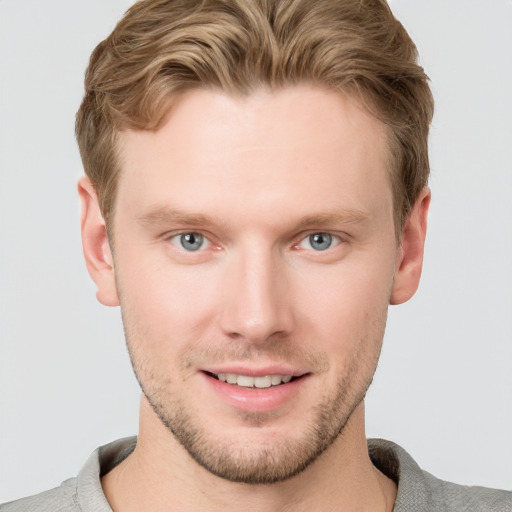 Joyful white young-adult male with short  brown hair and blue eyes