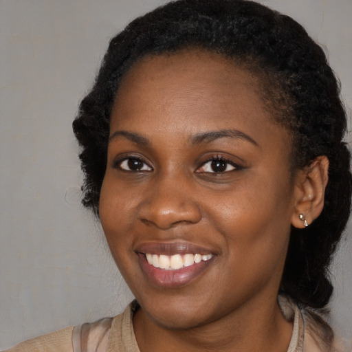 Joyful black young-adult female with short  black hair and brown eyes