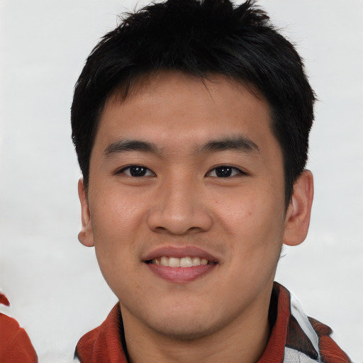 Joyful asian young-adult male with short  brown hair and brown eyes