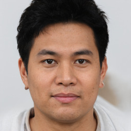 Joyful asian young-adult male with short  brown hair and brown eyes