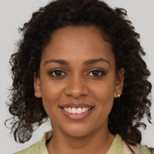 Joyful black young-adult female with medium  brown hair and brown eyes