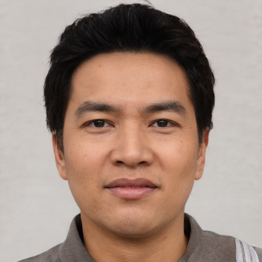 Joyful asian young-adult male with short  black hair and brown eyes