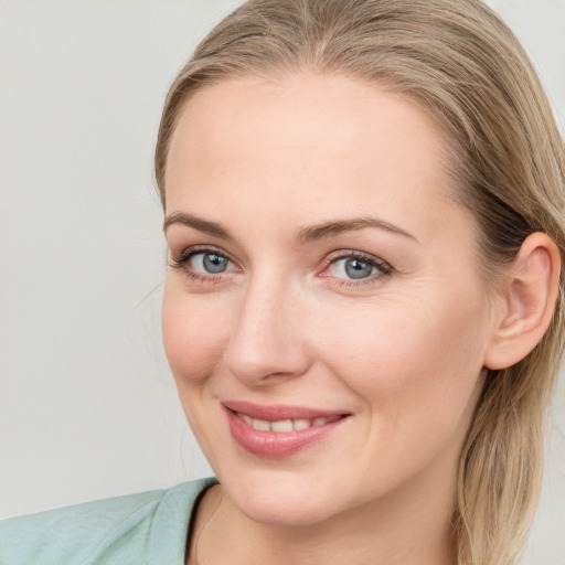 Joyful white young-adult female with long  brown hair and blue eyes