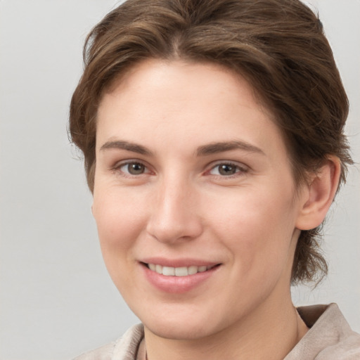 Joyful white young-adult female with short  brown hair and grey eyes