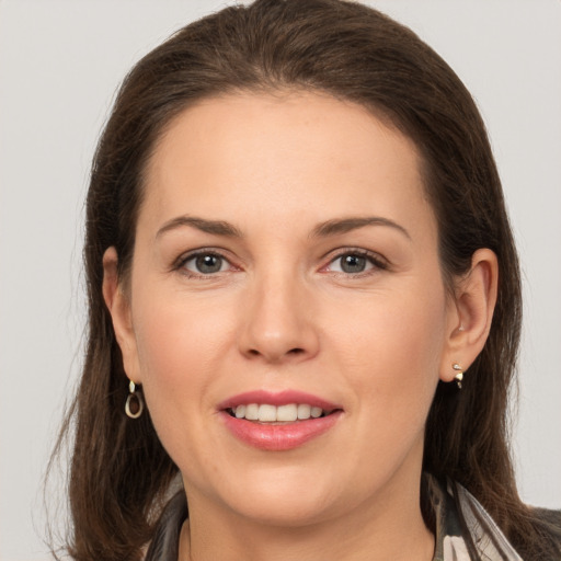 Joyful white young-adult female with long  brown hair and grey eyes