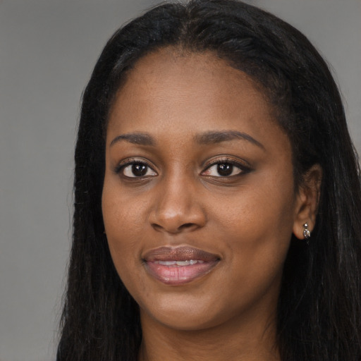 Joyful black young-adult female with long  brown hair and brown eyes