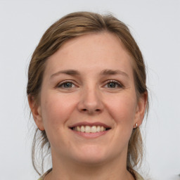 Joyful white young-adult female with medium  brown hair and grey eyes