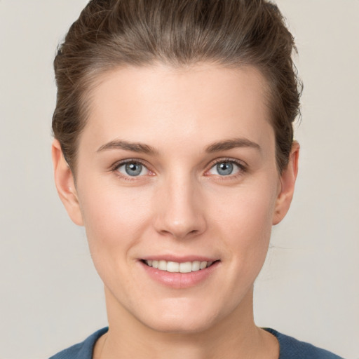 Joyful white young-adult female with short  brown hair and grey eyes