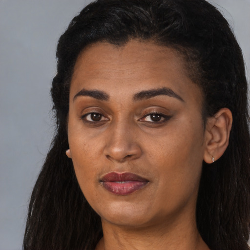 Joyful black young-adult female with long  black hair and brown eyes
