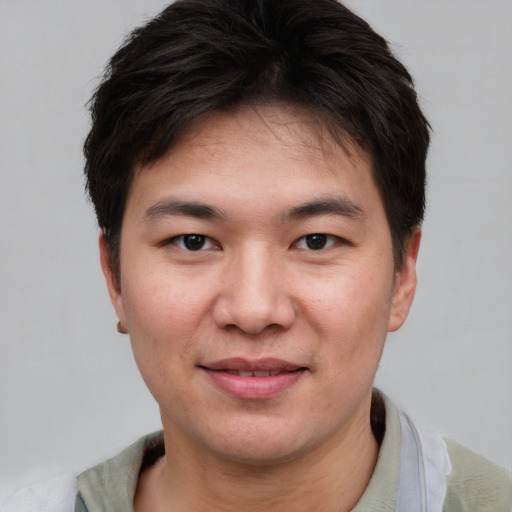 Joyful asian young-adult male with short  brown hair and brown eyes