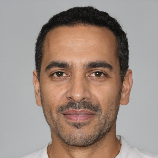 Joyful latino adult male with short  black hair and brown eyes