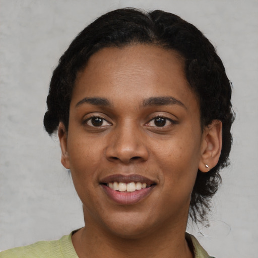 Joyful black young-adult female with short  black hair and brown eyes