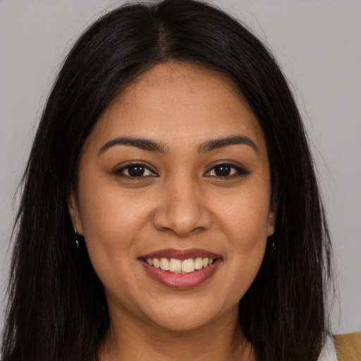 Joyful latino young-adult female with long  brown hair and brown eyes