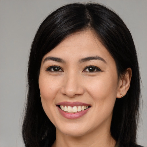 Joyful asian young-adult female with long  brown hair and brown eyes
