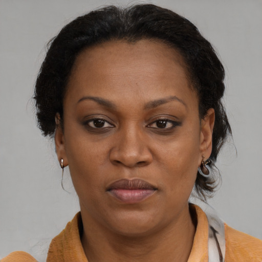 Joyful black adult female with medium  brown hair and brown eyes